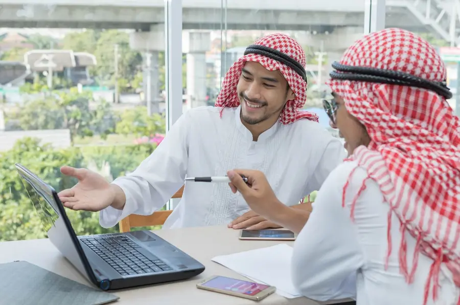 Two colleagues reviewing an app project on a laptop